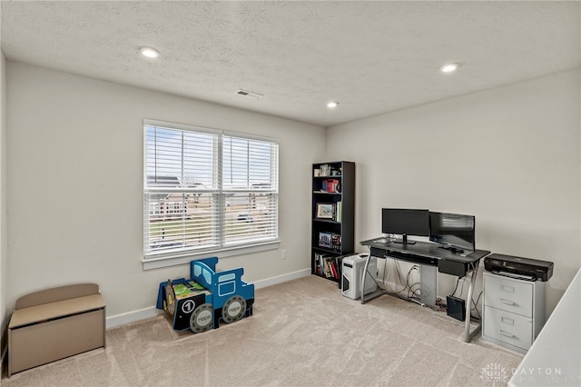 carpeted office space featuring a textured ceiling