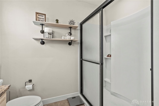 bathroom featuring vanity, an enclosed shower, and toilet