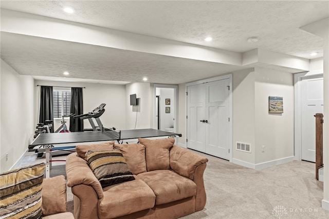 carpeted living room featuring a textured ceiling