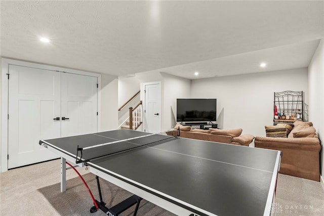 game room with light carpet and a textured ceiling