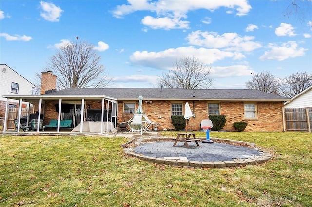 back of property with a yard, a sunroom, and a patio