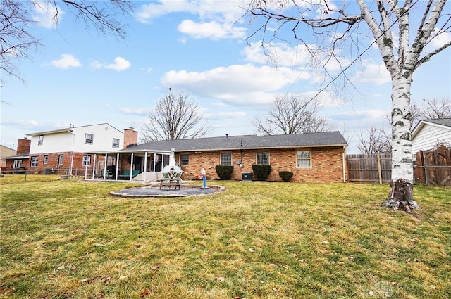 back of property featuring a sunroom, a yard, and a patio area