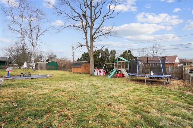 view of yard featuring a trampoline, a storage shed, and a playground