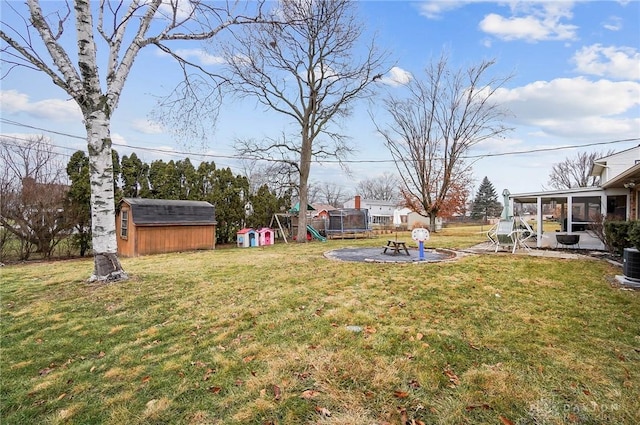 view of yard featuring a playground, a trampoline, and a shed