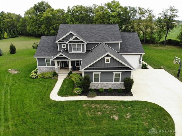 craftsman-style home with a garage, a front lawn, and covered porch