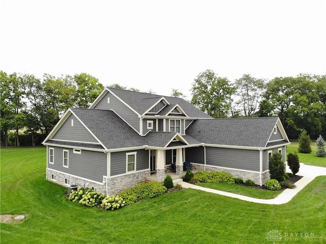 craftsman inspired home featuring a front lawn and central air condition unit