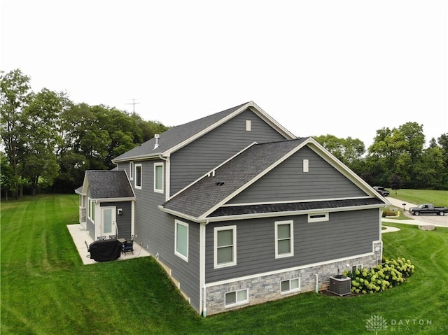 view of side of property with central AC unit, a lawn, and a patio area