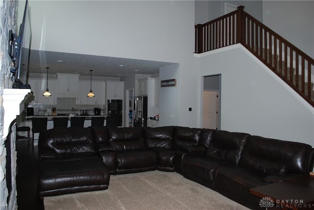 living room featuring carpet floors and a towering ceiling