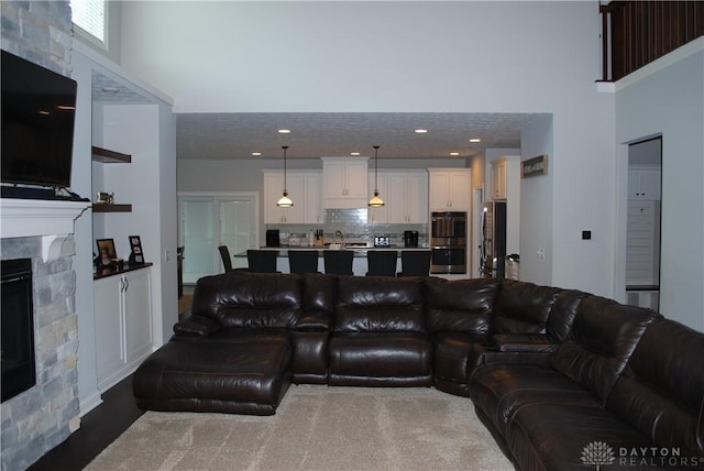 living room with sink, a towering ceiling, and a fireplace