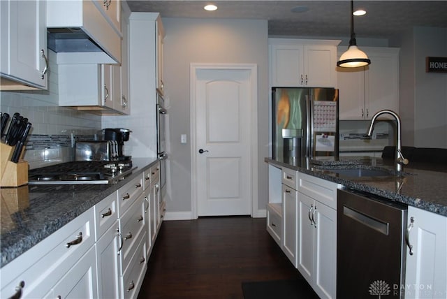 kitchen with decorative light fixtures, white cabinetry, sink, dark stone counters, and stainless steel appliances