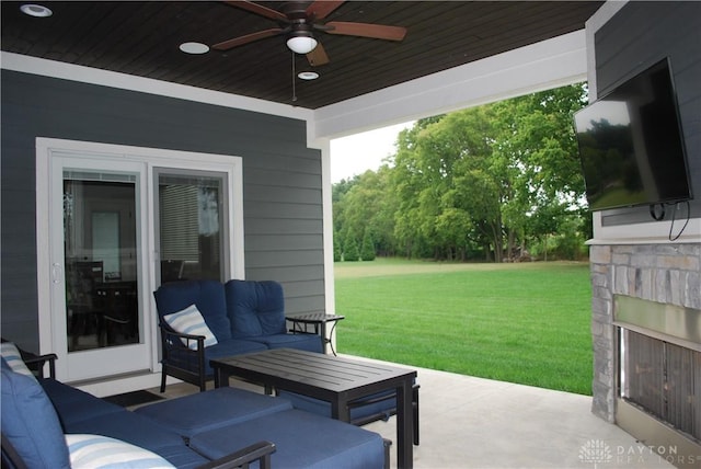 view of patio featuring ceiling fan and an outdoor living space with a fireplace