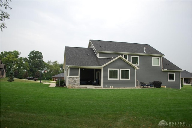 rear view of property with a yard and a patio