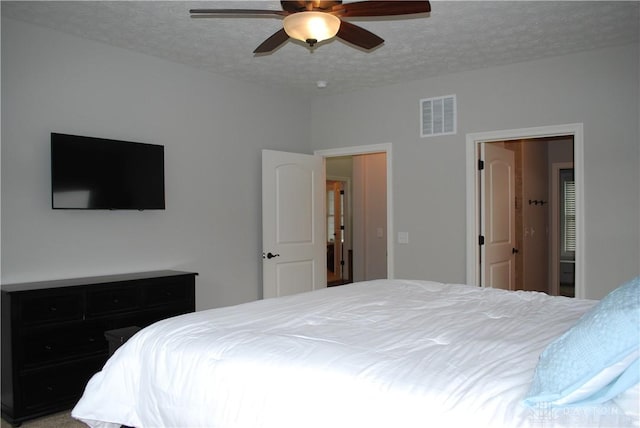 bedroom with ceiling fan and a textured ceiling