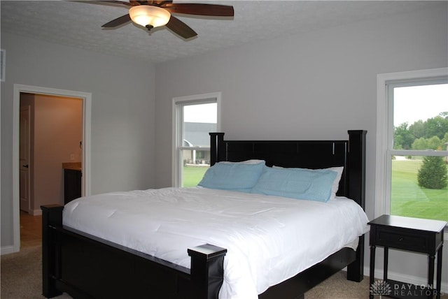 bedroom featuring ensuite bathroom, carpet floors, ceiling fan, and a textured ceiling