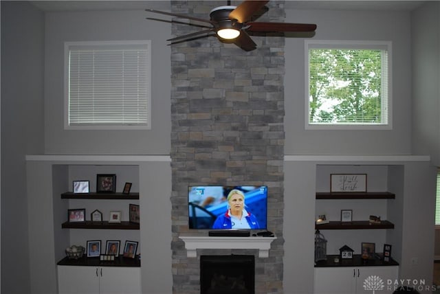 living room with ceiling fan and a fireplace