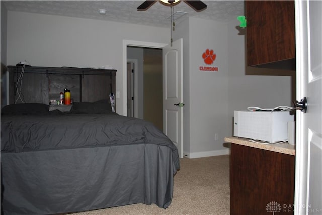 bedroom with ceiling fan, light colored carpet, and a textured ceiling