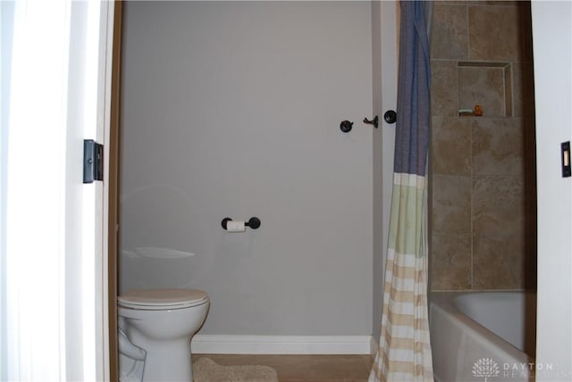 bathroom featuring shower / bathtub combination with curtain and toilet