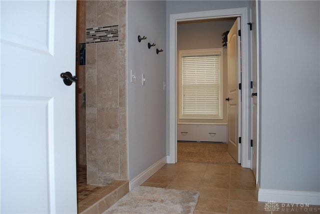 bathroom featuring tile patterned flooring and a tile shower