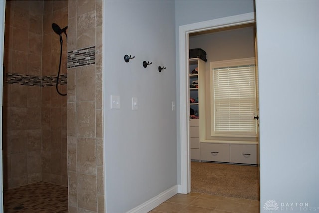 bathroom with tile patterned floors and a tile shower