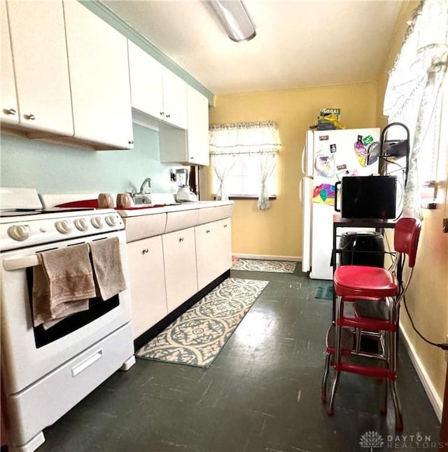 kitchen with white appliances, sink, and white cabinets