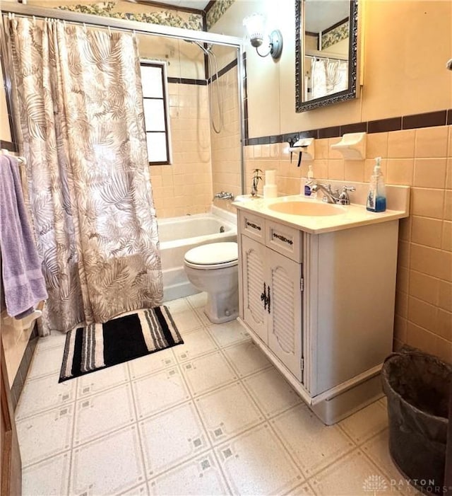 full bathroom featuring vanity, tile walls, shower / bath combo with shower curtain, and toilet