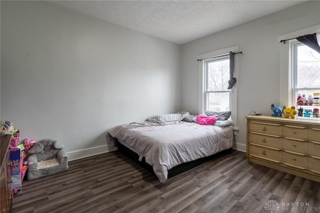 bedroom with dark hardwood / wood-style flooring and a textured ceiling