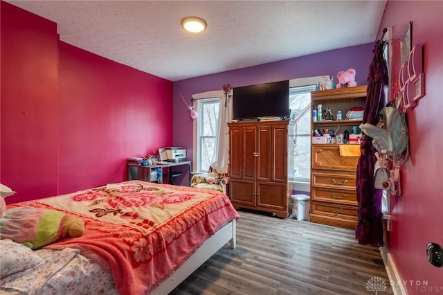 bedroom featuring dark wood-type flooring and a textured ceiling