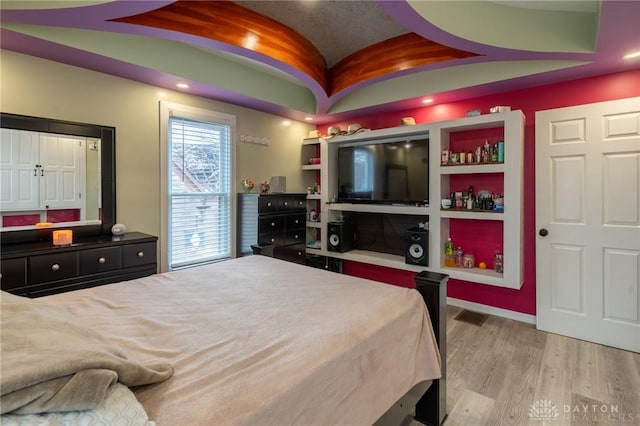 bedroom with lofted ceiling and light hardwood / wood-style floors