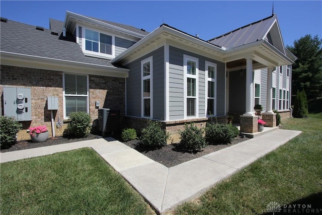 view of front facade with cooling unit and a front lawn