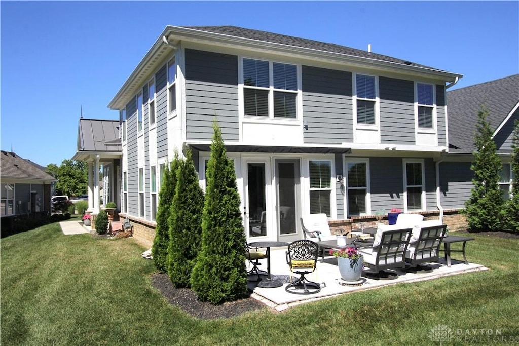 rear view of house featuring a yard and a patio