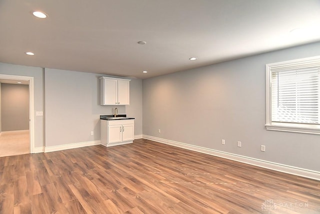 9460 Banyan Ct, Centerville, OH 45458 - unfurnished living room with recessed lighting, wood finished floors, baseboards, and a sink