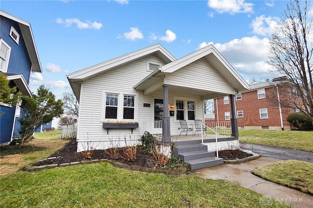 bungalow with a front yard and covered porch