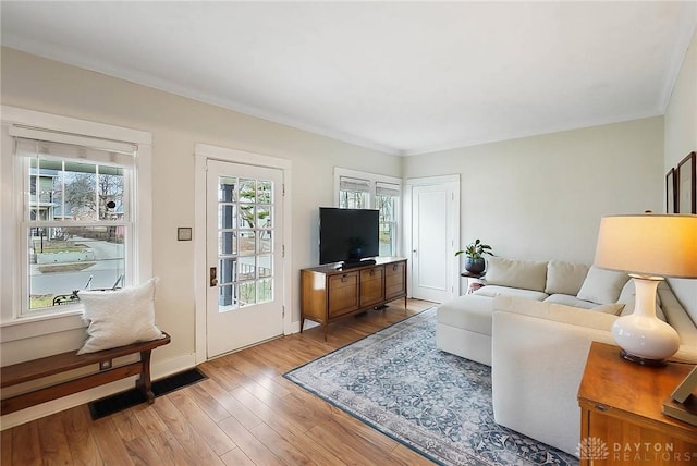 living room featuring ornamental molding and light hardwood / wood-style floors