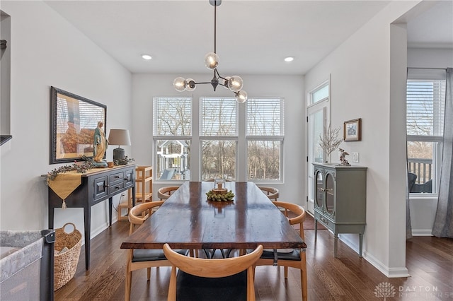 dining space with plenty of natural light, dark hardwood / wood-style flooring, and a notable chandelier