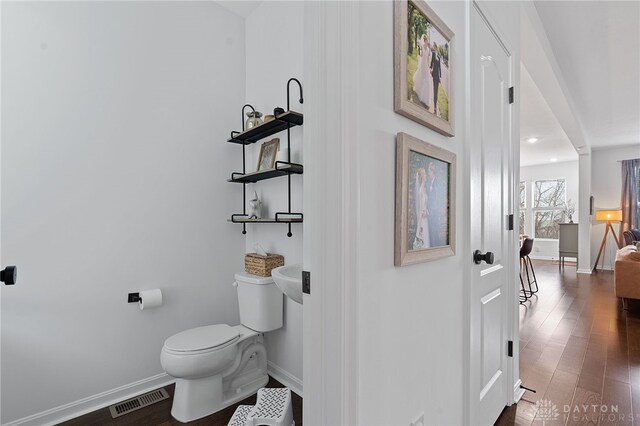 bathroom with wood-type flooring and toilet