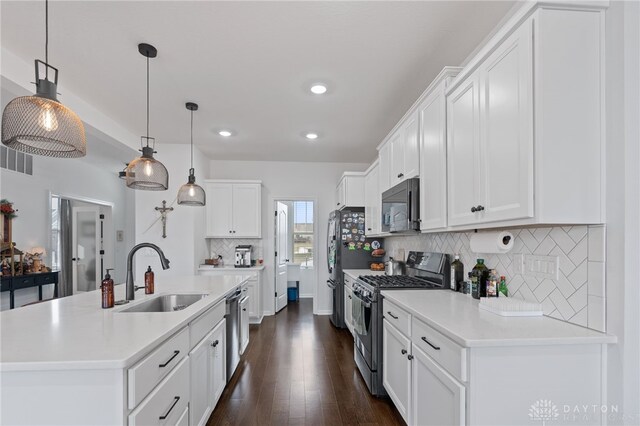 kitchen featuring sink, decorative light fixtures, stainless steel appliances, and white cabinets