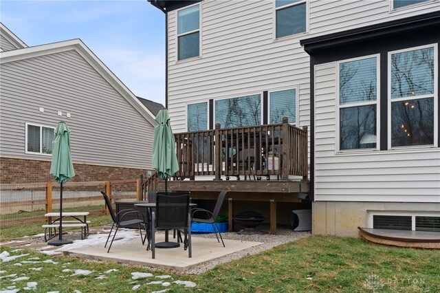 back of property with a wooden deck, a yard, and a patio