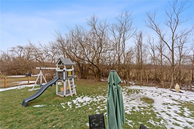 yard covered in snow featuring a playground