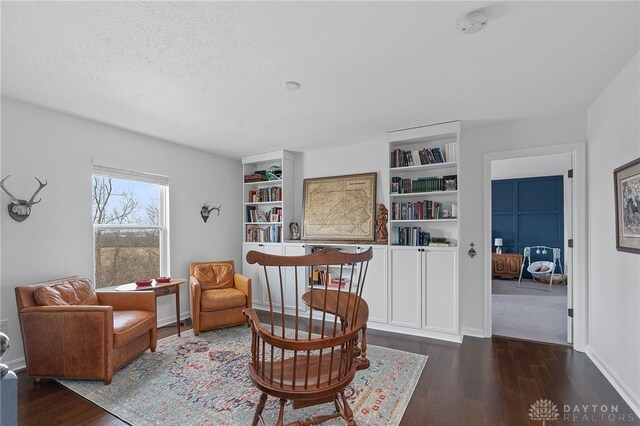 sitting room featuring dark wood-type flooring and a textured ceiling