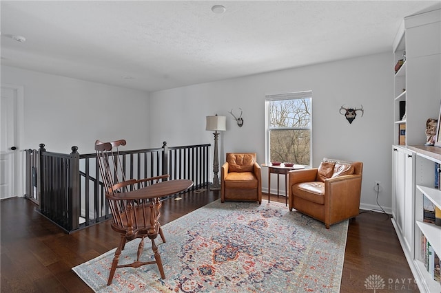 sitting room with dark hardwood / wood-style floors and a textured ceiling