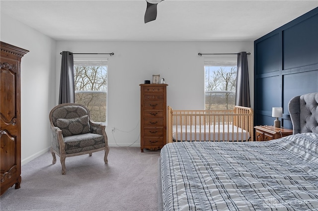 carpeted bedroom with ceiling fan and multiple windows