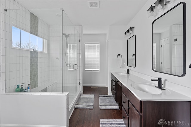 bathroom with a shower with door, vanity, and wood-type flooring