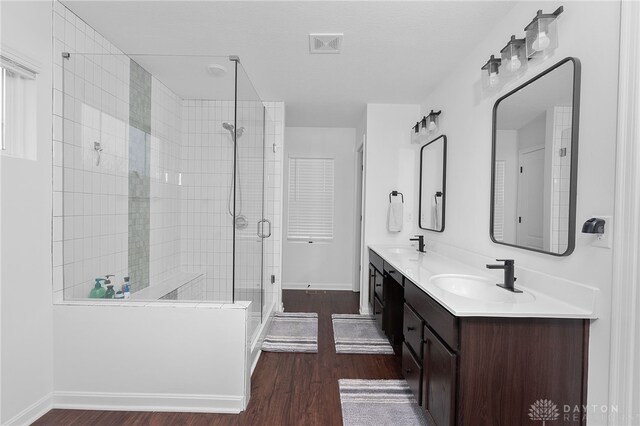 bathroom featuring hardwood / wood-style flooring, vanity, and a shower with door