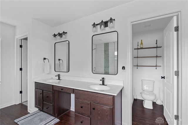 bathroom featuring vanity, wood-type flooring, a shower with door, and toilet