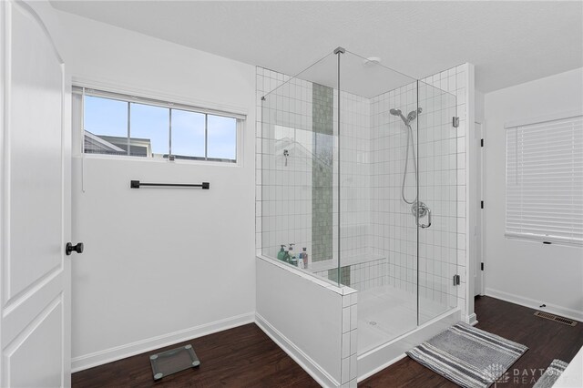 bathroom with a shower with door and wood-type flooring