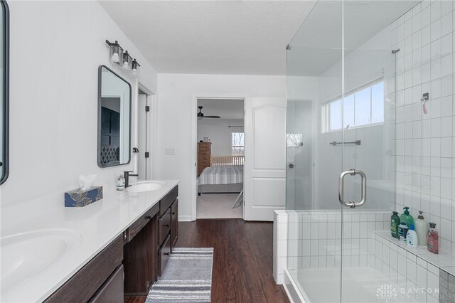 bathroom featuring an enclosed shower, wood-type flooring, a textured ceiling, vanity, and ceiling fan