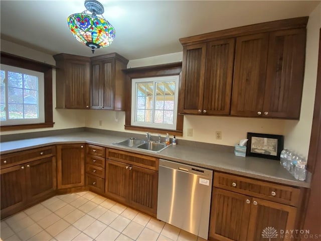 kitchen featuring plenty of natural light, sink, stainless steel dishwasher, and decorative light fixtures