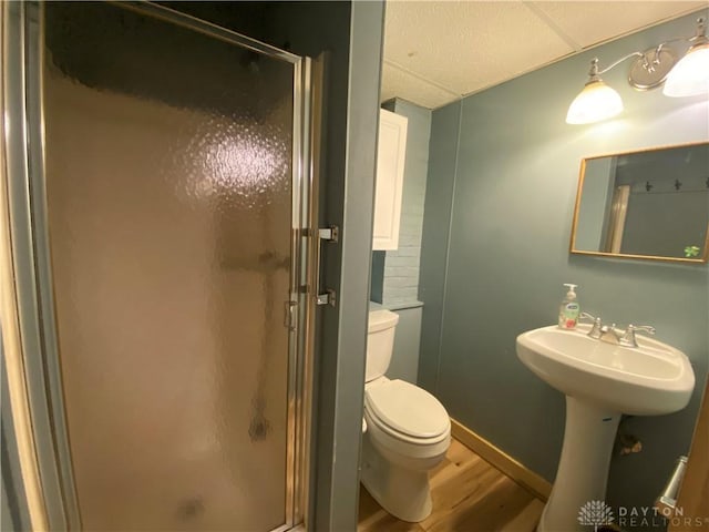 bathroom featuring sink, wood-type flooring, a shower with door, and toilet