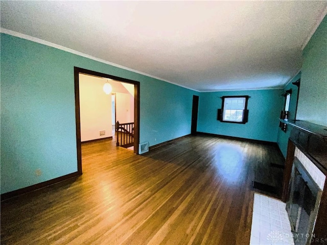 unfurnished living room featuring hardwood / wood-style floors, a fireplace, and ornamental molding