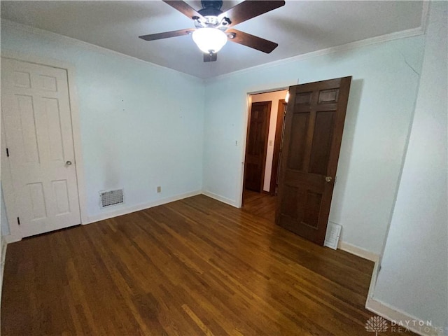 unfurnished bedroom featuring dark hardwood / wood-style flooring, ornamental molding, and ceiling fan